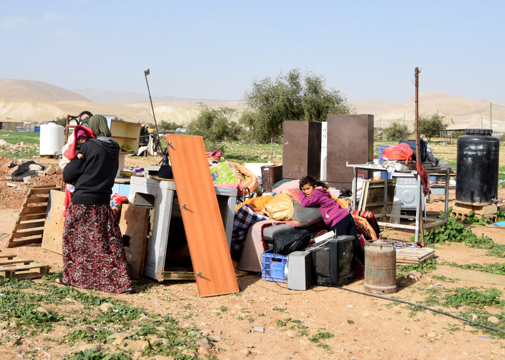 Family members next to the contents 0of their demolished home in Fasayil al-Wasta. Photo by 'Aref Dagharmeh, B'Tselem, 16 Jan. 2