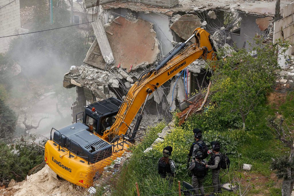 Israeli Border Police officers stand guard while anIsraeli bulldozer demolish a Palestinian building, Bethlehem, April 2, 2019. (Wisam Hashlamoun/Flash90)