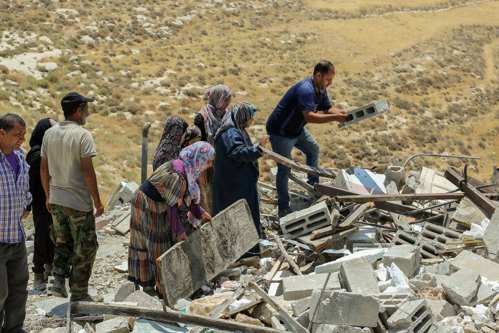 Palestinians pick through houses demolished by Israeli authorities in the West Bank village of Khalat Aldabe, south of Yatta, June 17, 2019. (Wissam Hashlamon/Flash90)