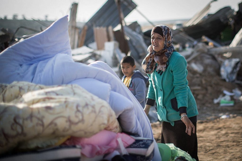 Bedouin collect their belongings from the ruins of their demolished homes in the unrecognized village of Umm al-Hiran in the Negev desert, in the in the Southern Israel, January 18, 2017. (Hadas Parush/Flash90)