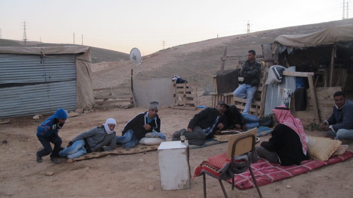 Bedouin lying on mattresses in the unrecognized West Bank village of Khan al-Ahmar. Photo by Amira Hass.